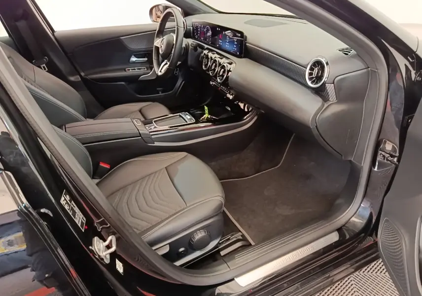 Intérieur noir de la Mercedes Classe A 250 e Business Line 2023 vu côté conducteur, tableau de bord et sièges en cuir.