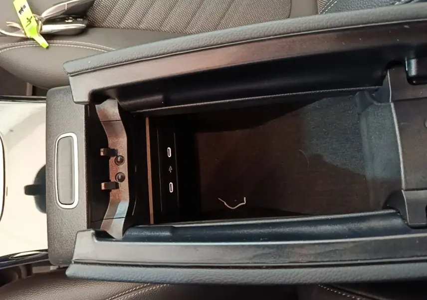 Vue rapprochée de la console centrale ouverte d’une Mercedes Classe A 250 e Business Line noire, montrant les ports USB.