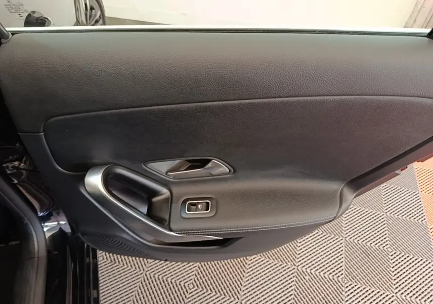 Vue rapprochée de la porte intérieure côté gauche noire de la Mercedes Classe A 250 e Business Line 2023.