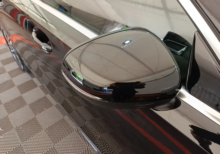 Gros plan sur le rétroviseur droit noir brillant d’une Mercedes Classe A 250 e Business Line 2023.