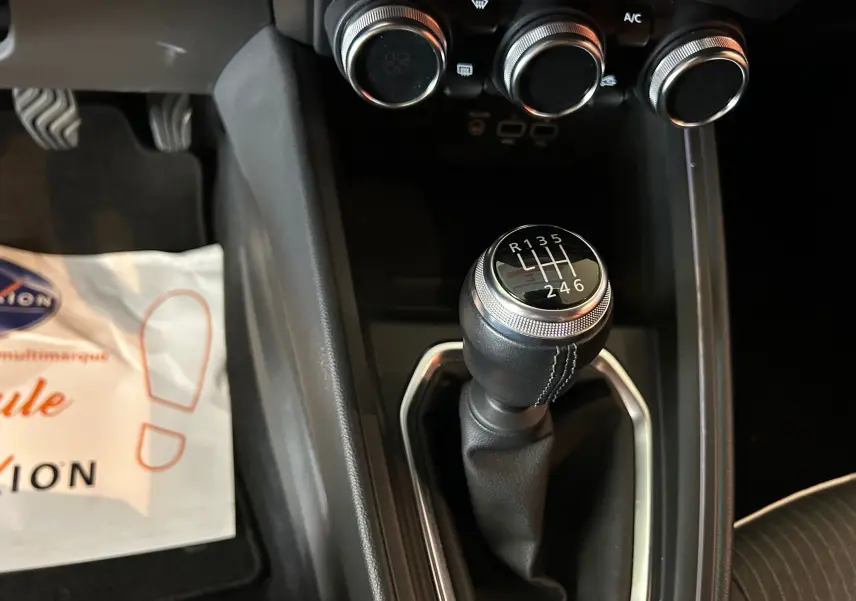 Le levier de vitesses manuel de la Renault Clio V 1.0 TCE 90 CH Intens, avec les commandes de climatisation en arrière-plan.