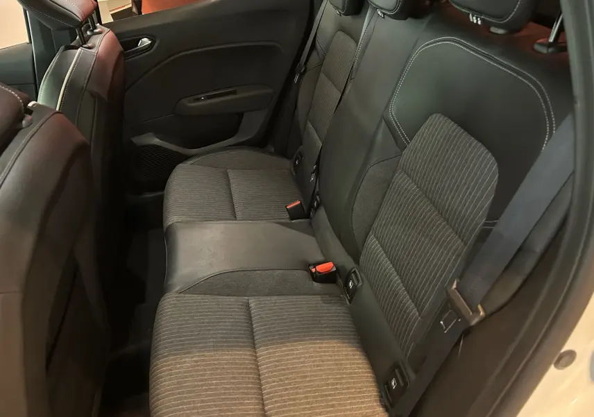 Vue intérieure côté droit des sièges arrière en tissu gris et cuir noir de la Renault Clio V blanche nacrée.