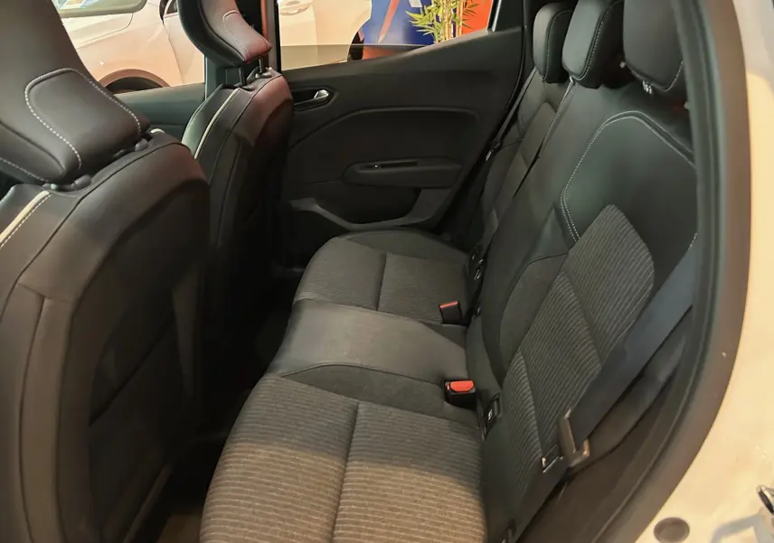 Vue intérieure côté droit sur la banquette arrière en tissu gris et cuir noir de la Renault Clio V blanc nacré.