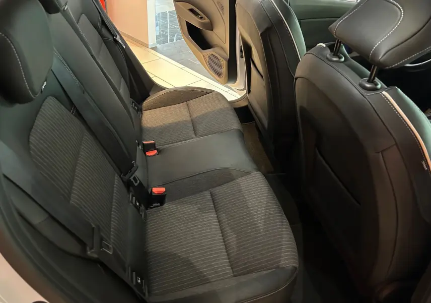 Vue intérieure arrière côté gauche de la Renault Clio V 2021, sièges tissu gris et cuir noir, porte ouverte.