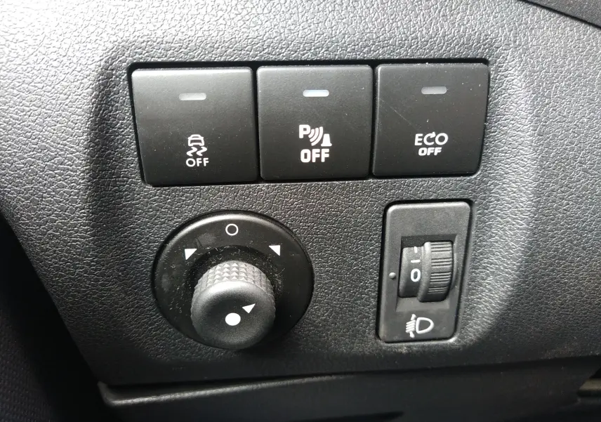 Gros plan sur les commandes de régulation de traction, stationnement et mode ECO du tableau de bord du Peugeot Partner Tepee brun 2017.