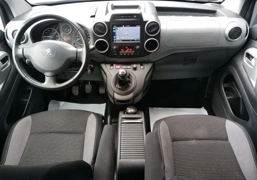 Vue intérieure avant du Peugeot Partner Tepee 2017, tableau de bord avec écran GPS et sièges tissu gris.