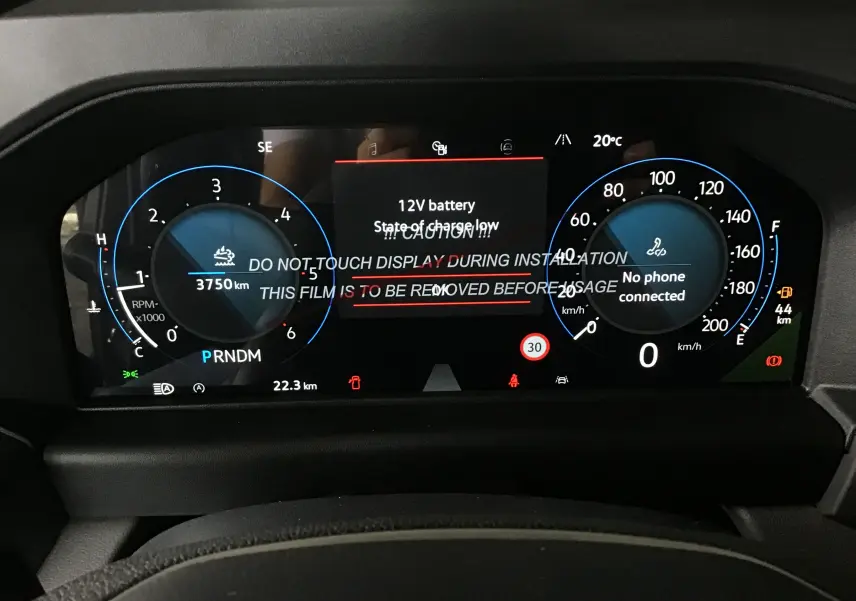 Vue rapprochée du tableau de bord numérique du Volkswagen Transporter T7 gris anthracite, affichant les compteurs et alertes.