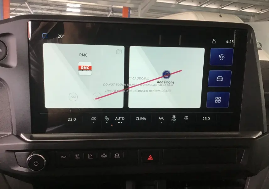 Écran tactile central du Volkswagen Transporter T7 gris anthracite, affichant la radio RMC et l'option ajout téléphone.