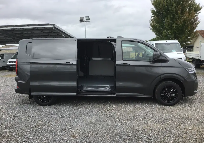 Vue latérale droite d'un Volkswagen Transporter gris anthracite 2025 avec porte coulissante ouverte et jantes noires.