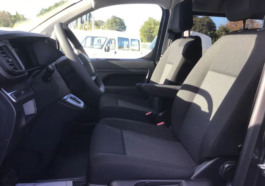 Vue intérieure côté conducteur du Citroën Jumpy gris titane, montrant les sièges avant et le volant.