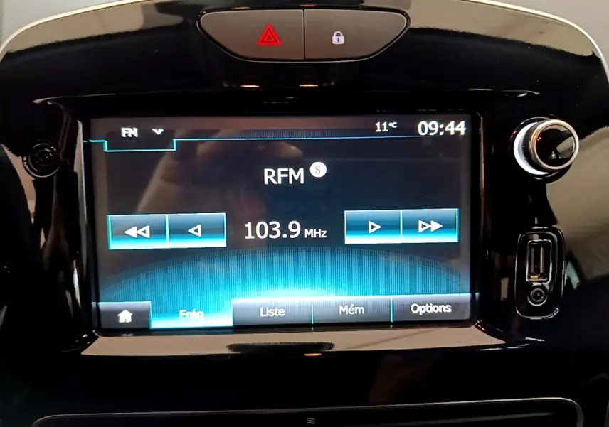 Écran tactile central allumé de la Renault Clio Business TCe 90 2019, affichant la radio sur fond noir brillant.
