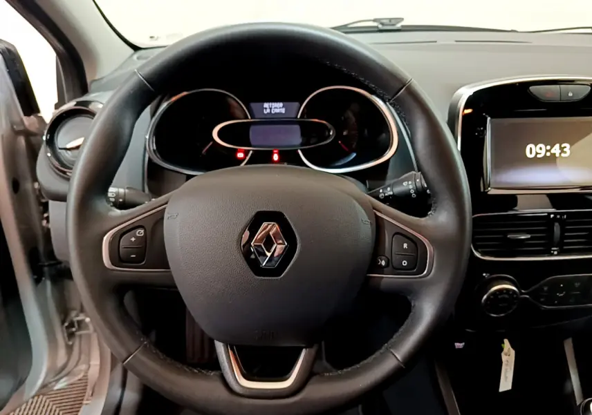 Vue intérieure centrée sur le volant cuir noir d'une Renault Clio Business TCe 90 avec tableau de bord et écran tactile.