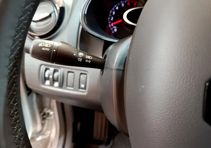 Gros plan sur la manette des phares et le volant gris foncé de la Renault Clio Business TCe 90 2019.