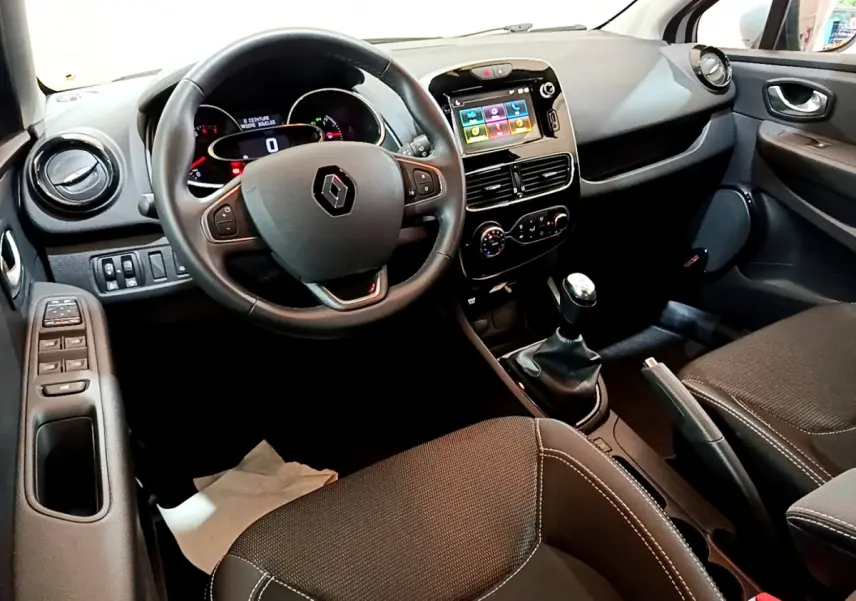 Intérieur avant droit de la Renault Clio Business TCe 90 2019, volant cuir, écran tactile et boîte manuelle visibles.