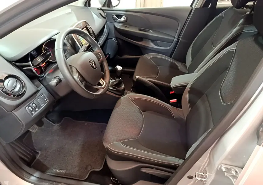 Intérieur de Renault Clio Business TCe 90 gris clair, vue côté conducteur avec volant cuir et tableau de bord tactile.