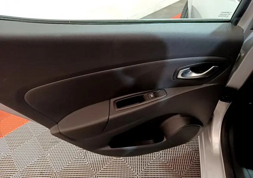 Vue rapprochée de la porte avant droite grise claire de la Renault Clio Business TCe 90 avec poignée et commande de vitre.