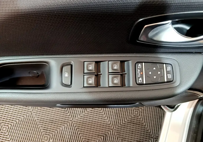 Vue rapprochée de la commande des vitres et rétroviseurs côté conducteur d'une Renault Clio Business gris clair 2019.