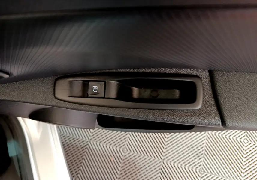 Bouton de commande de lève-vitre côté conducteur sur porte intérieure d'une Renault Clio Business gris clair 2019.