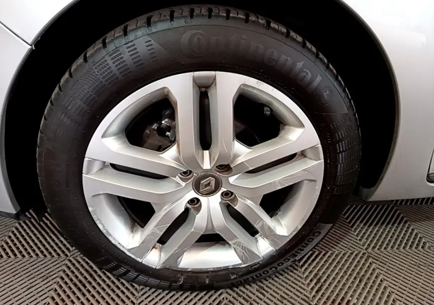 Gros plan sur la roue avant gauche d'une Renault Clio Business TCe 90 gris clair, avec partie de la carrosserie visible.