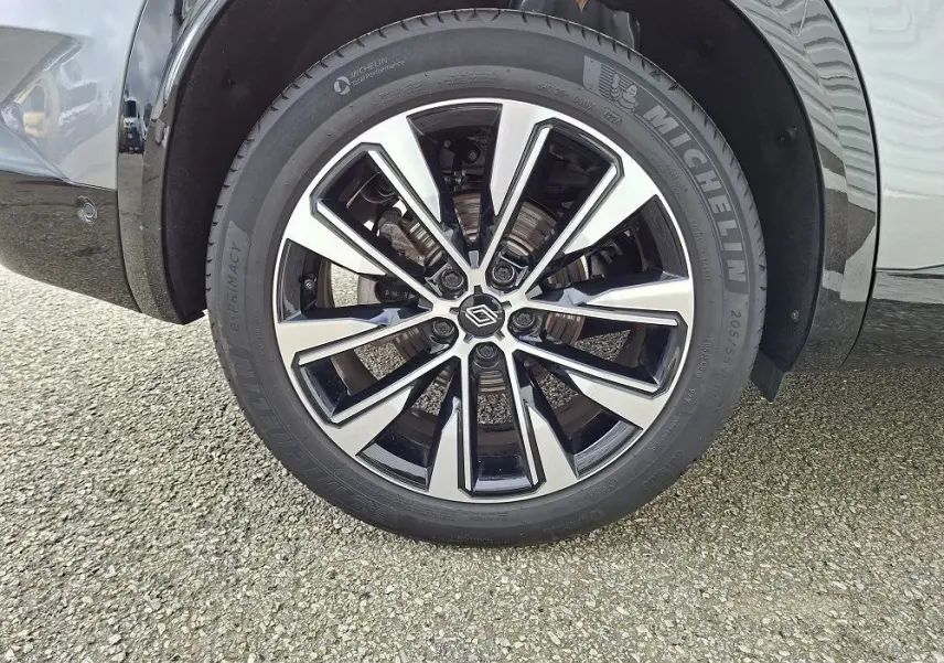 Gros plan sur la roue avant droite du Renault Austral gris schiste, avec jante alliage bicolore et pneu Michelin.