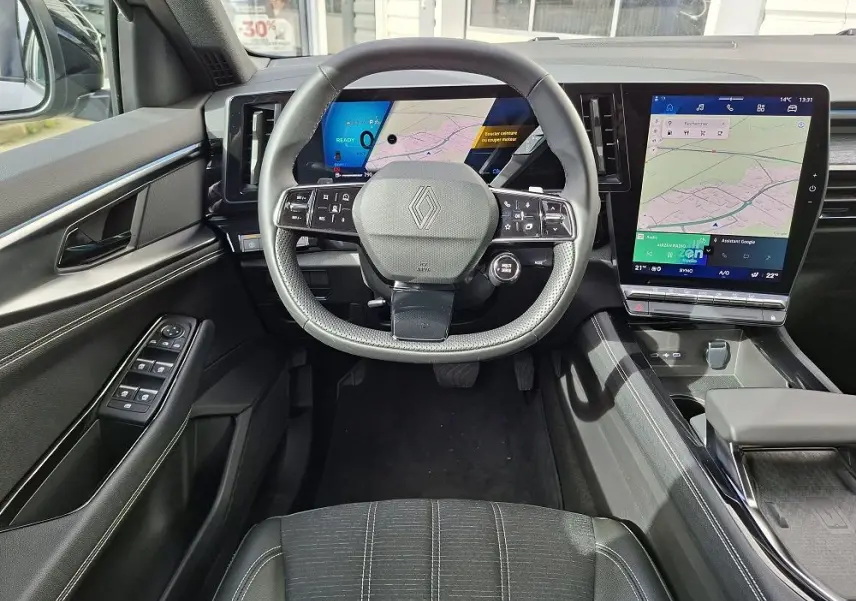 Vue intérieure centrée sur le volant de la Renault Austral gris schiste, avec tableau de bord numérique et grand écran tactile vertical.