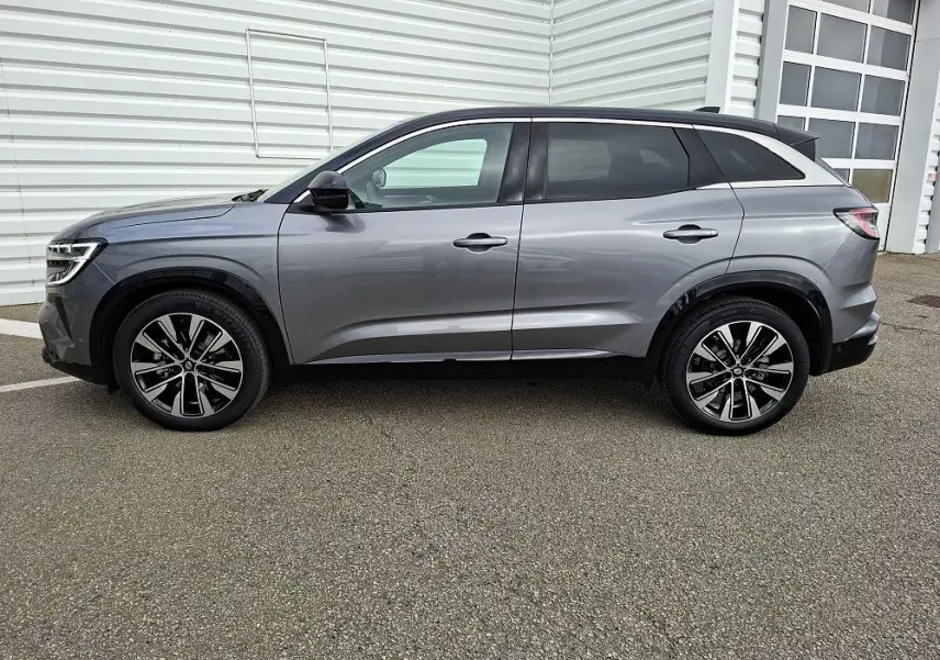 Renault Austral E-Tech gris schiste vu de profil côté gauche, avec jantes alliage et lignes épurées.