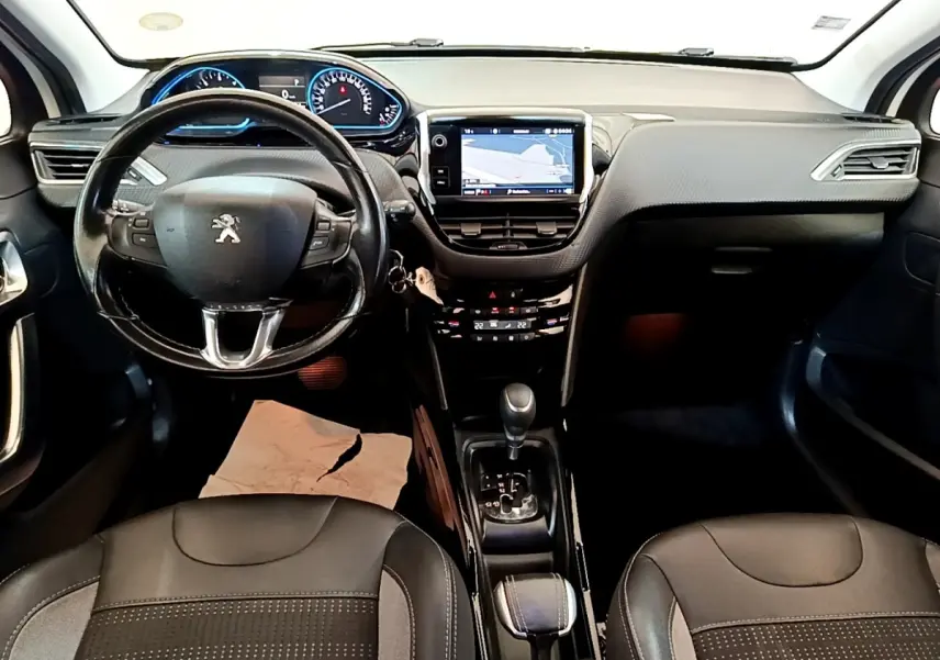 Vue intérieure avant du Peugeot 2008 2019 avec tableau de bord noir, écran tactile de navigation et volant cuir multifonctions.