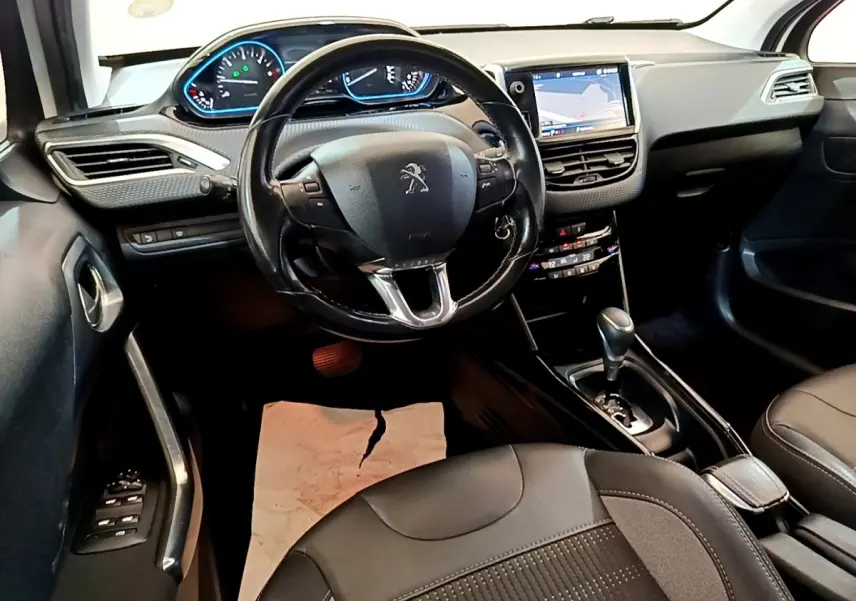 Vue intérieure du poste de conduite du Peugeot 2008 2019 avec volant cuir noir et écran tactile central allumé.