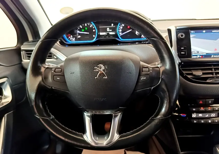 Vue rapprochée du volant cuir Peugeot 2008 2019 avec tableau de bord digital et écran tactile de navigation visible.