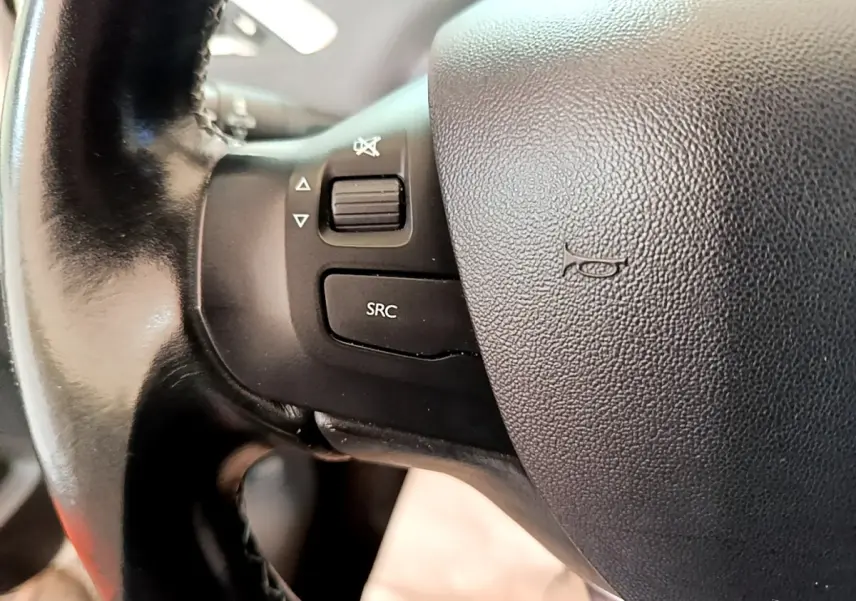 Gros plan sur le volant cuir noir de la Peugeot 2008 2019 avec commandes audio intégrées côté gauche.