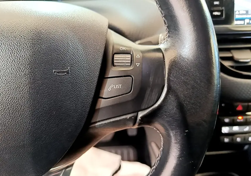 Gros plan sur le volant cuir noir de la Peugeot 2008 2019 avec commandes multifonctions et tableau de bord partiel visible.