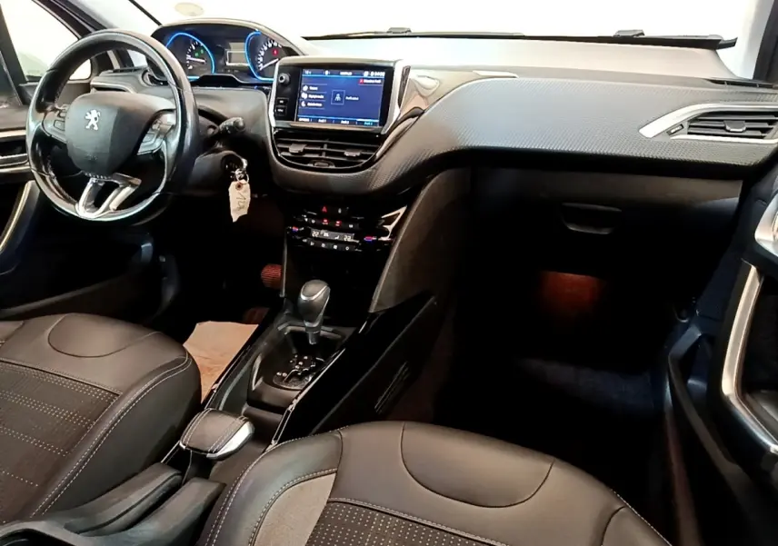 Vue intérieure avant droite du Peugeot 2008 2019, tableau de bord noir avec écran tactile et volant cuir multifonctions.