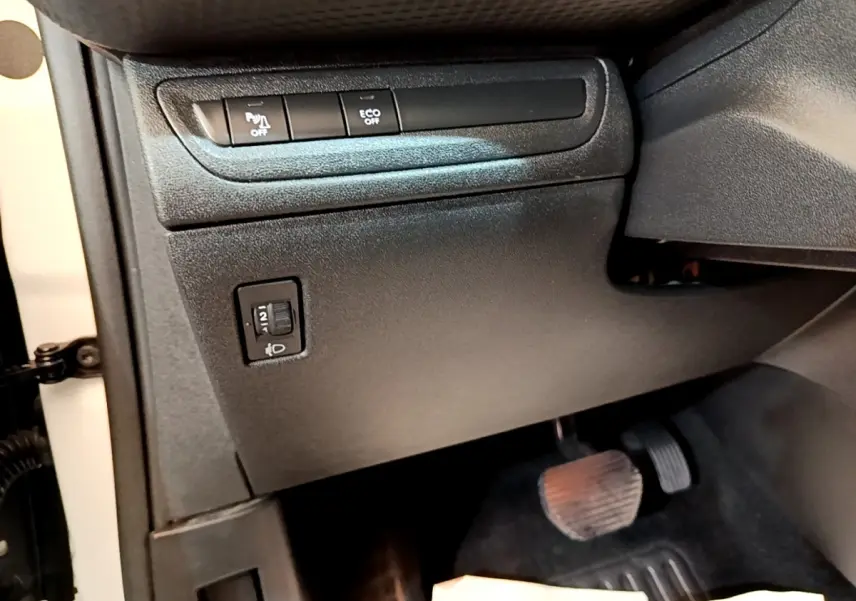 Vue intérieure côté conducteur du Peugeot 2008 2019, montrant les commandes noires sous le tableau de bord et les pédales.