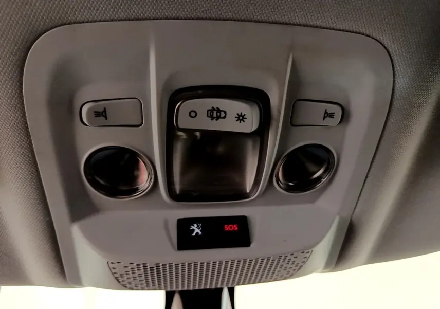 Vue en gros plan du plafonnier intérieur gris du Peugeot 2008 avec boutons d’éclairage et alerte SOS rouge allumée.