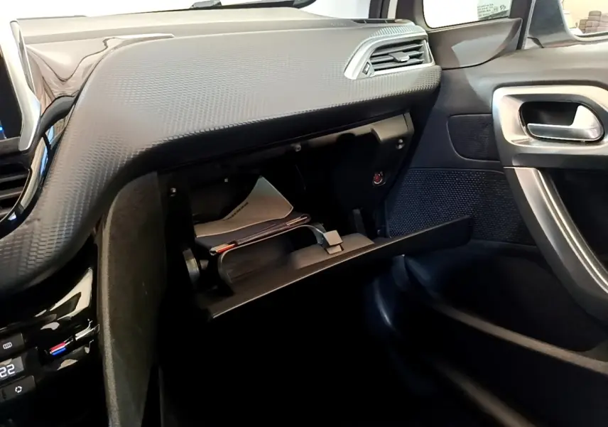 Vue intérieure côté passager du tableau de bord noir et boîte à gants ouverte du Peugeot 2008 2019 finition Allure Business.