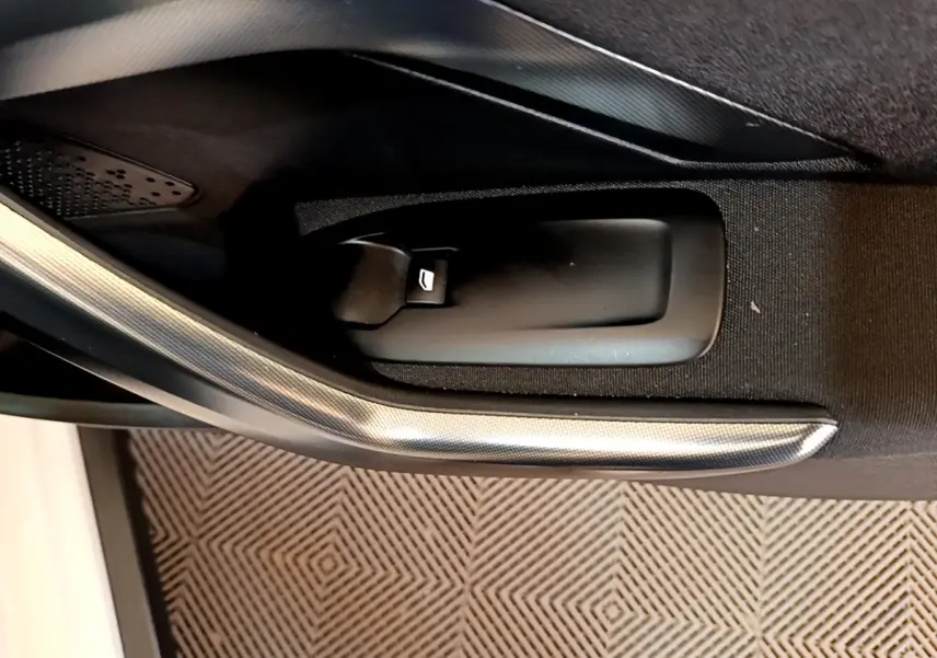 Détail de la poignée intérieure de porte côté conducteur du Peugeot 2008 2019 avec insert décoratif gris.