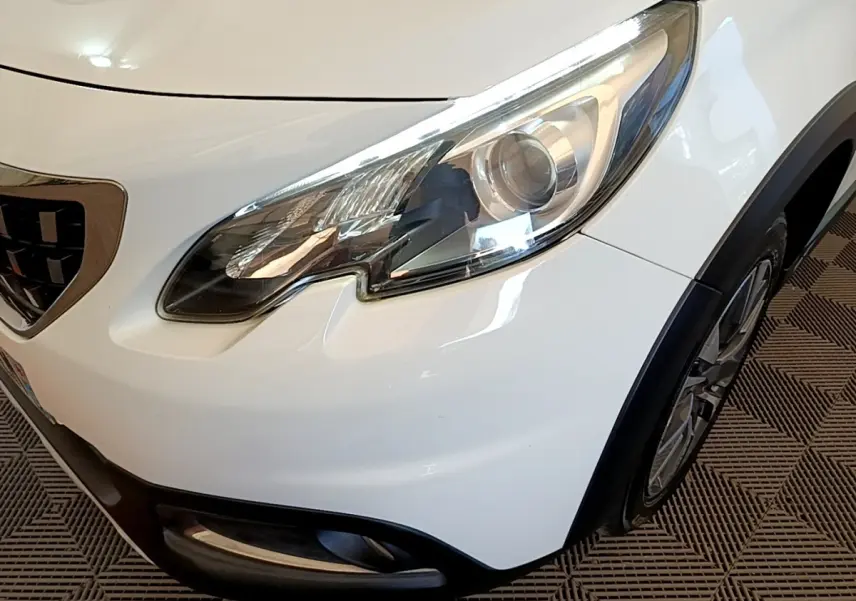 Gros plan sur l'avant droit blanc du Peugeot 2008, mettant en valeur le phare LED et la calandre chromée.