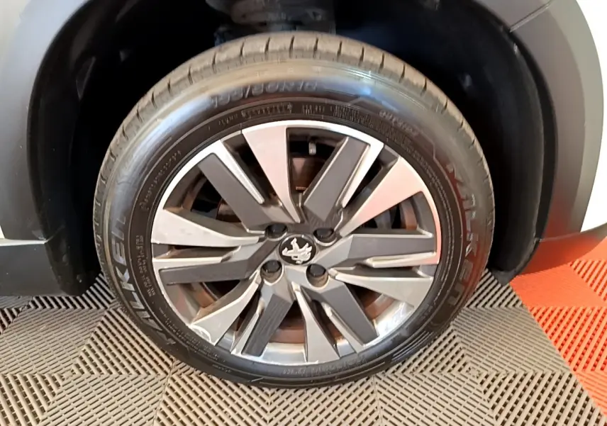 Gros plan sur la roue avant droite du Peugeot 2008 2019, jante alliage bicolore avec logo lion au centre.