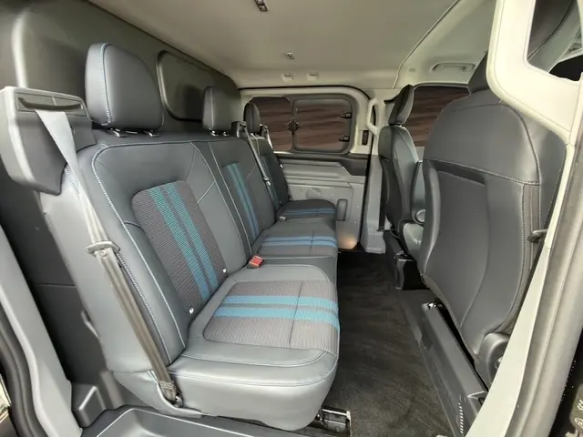 Vue intérieure côté droit du Ford Transit Fourgon 2026, montrant la banquette arrière noire avec surpiqûres bleues.