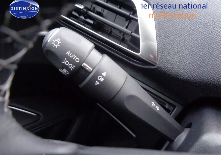 Gros plan sur la commande des feux et clignotants dans l'habitacle noir du Peugeot 3008 2023.