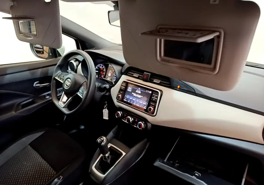 Intérieur de la Nissan Micra blanc, vue côté conducteur, tableau de bord avec écran tactile et volant multifonctions.