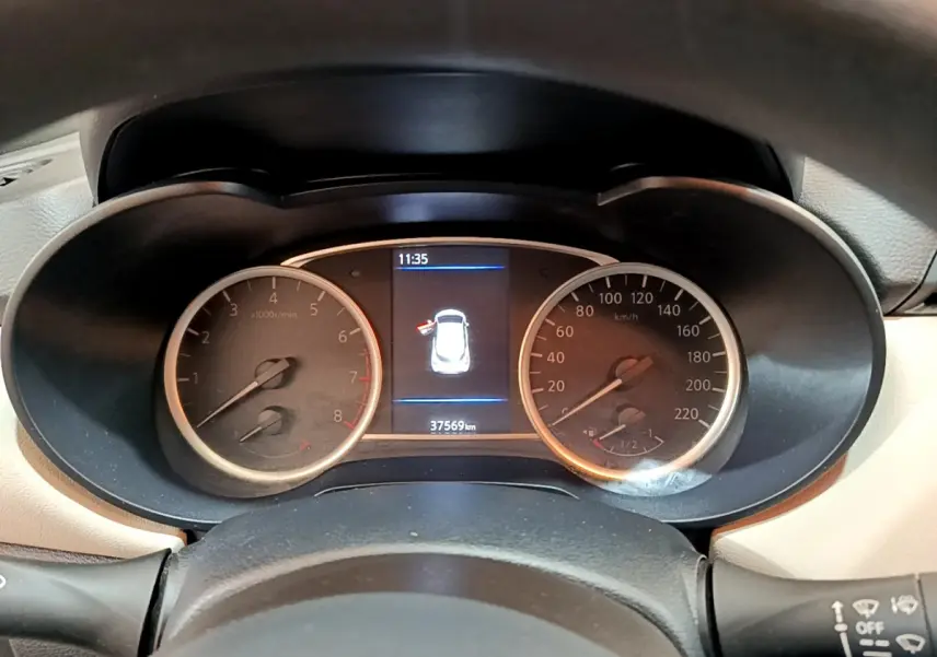 Vue rapprochée du tableau de bord de la Nissan Micra blanche, affichant compte-tours, vitesse et écran central numérique.