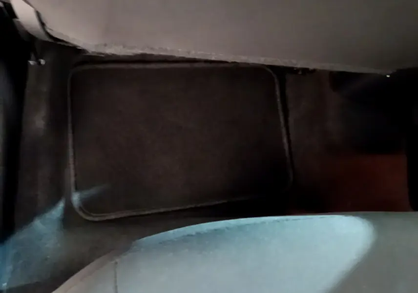 Vue rapprochée du tapis de sol noir au niveau du plancher arrière d'une Nissan Micra blanche 2022.