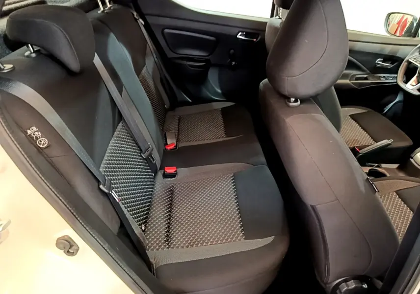 Vue intérieure côté gauche montrant les sièges arrière et avant noirs à motifs de la Nissan Micra blanche 2022.