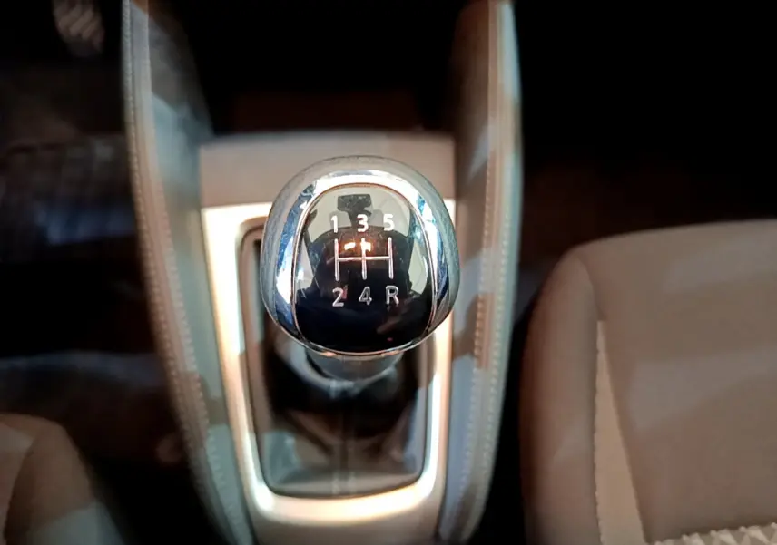 Gros plan sur le levier de vitesses manuel noir et chrome de la Nissan Micra IG-T 92 Acenta 2022, intérieur beige.