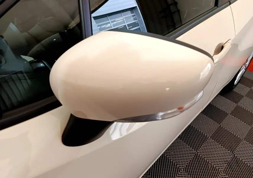 Rétroviseur côté gauche blanc de la Nissan Micra IG-T 92 Acenta 2022, vue rapprochée sur la portière et vitre.