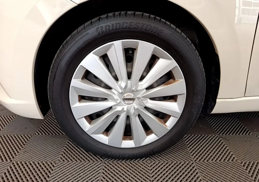 Gros plan sur la roue avant gauche blanche d'une Nissan Micra IG-T 92 Acenta 2022 avec jante en alliage et pneu Bridgestone.