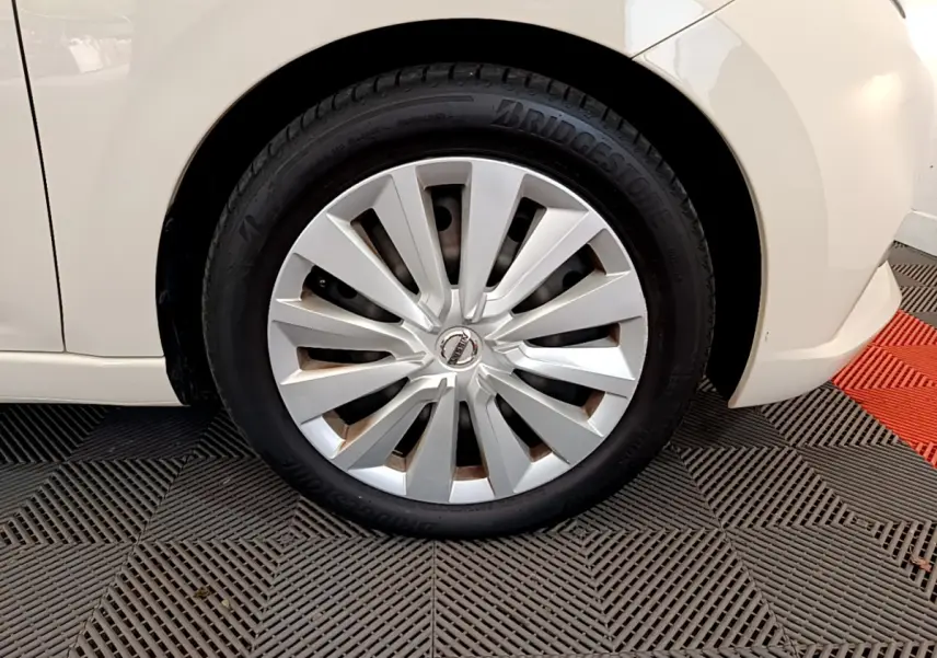 Gros plan sur la roue avant gauche blanche d'une Nissan Micra IG-T 92 Acenta 2022 avec enjoliveur argenté.