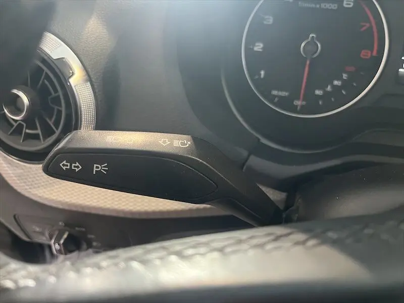 Gros plan sur la commande de clignotants à gauche du volant dans l'habitacle d'un Audi Q2 2021 bleu Navarre métal.