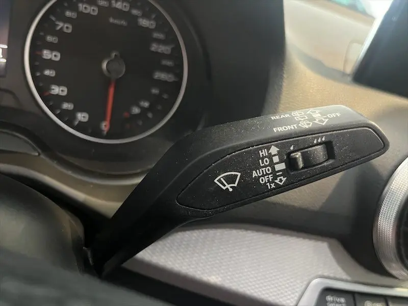 Le levier de commande des essuie-glaces dans l'habitacle d'un Audi Q2 30 TFSI bleu Navarre, vue rapprochée côté gauche.